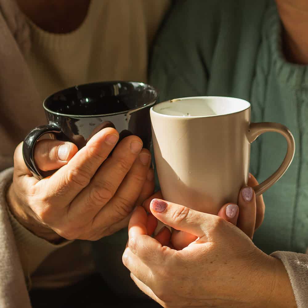 couple with different colored mugs
